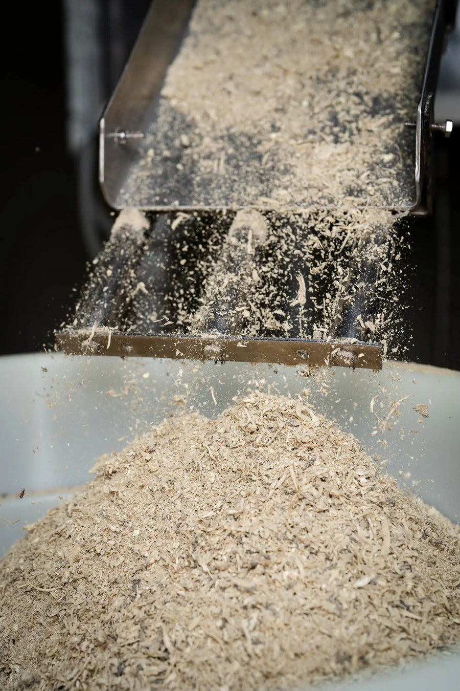 Dried kava root being thrown up inside a mill as it is ground to powder